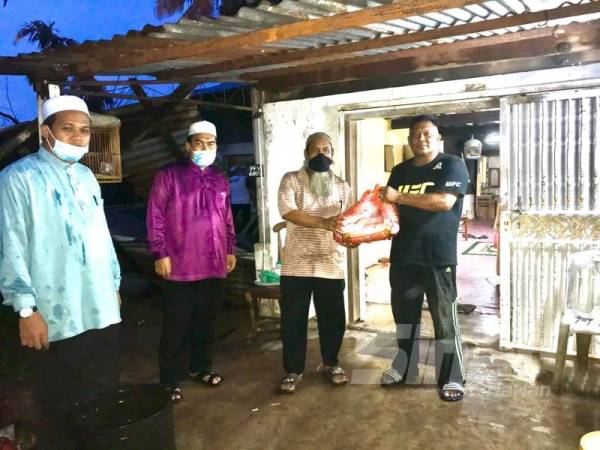 Ahmad Fadzli (dua kiri) menziarahi Hamdan (kanan) semalam bagi meringankan beban menyambut hari pertama Ramadan. 