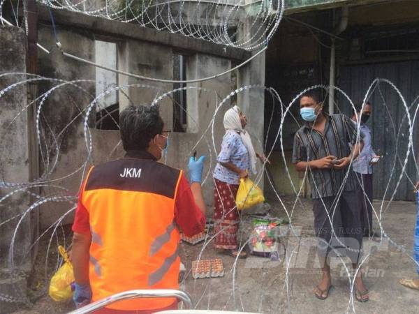 Petugas JKM menyalurkan makanan kepada penduduk PKPD Selayang Baru.