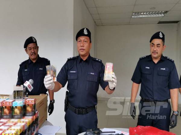 Mohd Khaizam menunjukkan rokok dan curut yang dirampas daripada pemandu teksi. 