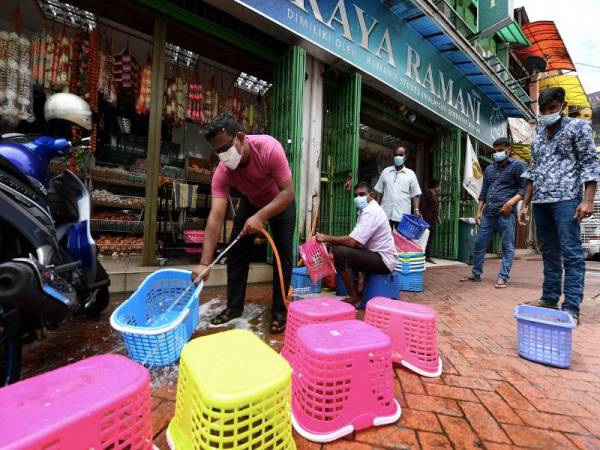 Pekerja-pekerja pasaraya Ramani di Lebuh Pasar hari ini, membasuh bakul-bakul yang digunakan pelanggan sebagai langkah mengekang penularan COVID-19. - Foto Bernama 
