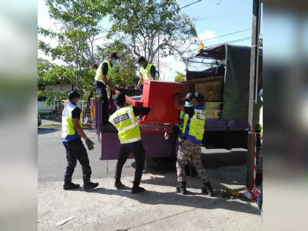 Anggota penguatkuasa MBAS mengangkut peralatan niaga yang disita dalam Ops Penjaja Ramadan di Bandaraya Alor Setar dan Pokok Sena semalam.