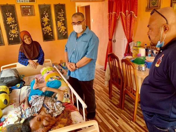 Tengku Ibrahim Farihaddin (tengah) melihat keadaan Mohd Hakimi Hakim yang terlantar di rumahnya.