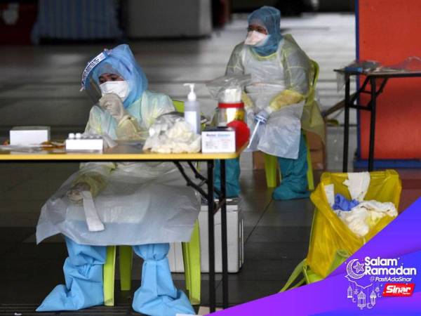 Petugas barisan hadapan Kementerian Kesihatan Malaysia (KKM) kepenatan ketika menjalankan saringan Covid-19 di Terminal Sentral Kuantan hari ini.- Foto Bernama