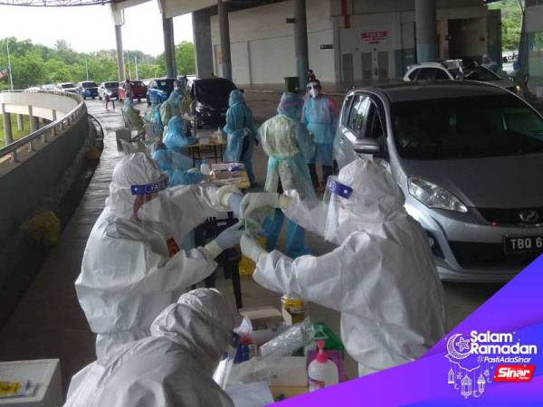 Petugas barisan hadapan Kementerian Kesihatan Malaysia (KKM) mengambil saringan Covid-19 di Terminal Sentral Kuantan hari ini.
