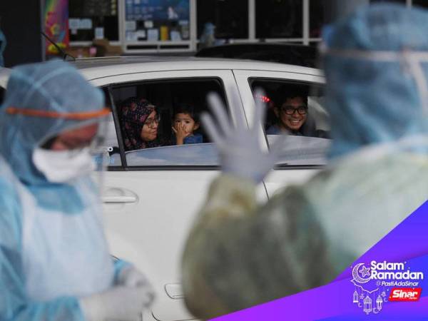 Adik Nur Addeena Sufiyyah Nor Aminuddin, 2, memberi "flying kiss" kepada petugas barisan hadapan Kementerian Kesihatan Malaysia (KKM) ketika bersama ayah Nor Aminuddin Ramli,30, dan ibu Sharkila Ismail Kamel, 30, membuat saringan Covid-19 hari ini. - Foto Bernama