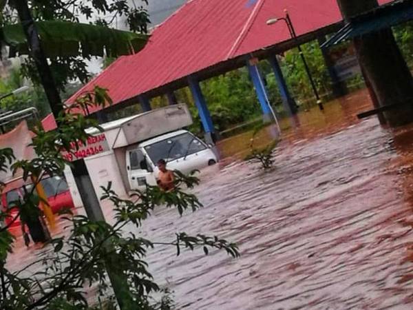 Sebuah van tersangkut dalam banjir kilat melanda Kampung Sungai Kertas hari ini.
