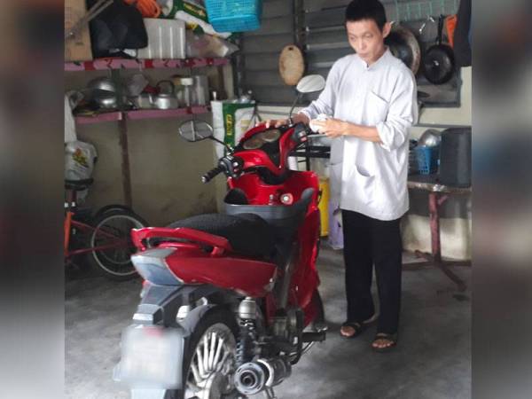 Muhammad Adam Lai membersihkan motosikal yang menjadi pengangkutan utamanya untuk mencari rezeki dengan menjual bertih jagung di sekitar Alor Setar.