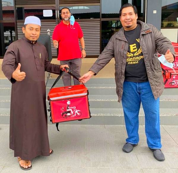 Ezuan (kanan) bersama Ahmad Fadhli (kiri) semasa gimik perasmian penyerahan beg penghantaran kepada ‘runner’ MyPasor.com di Masjid Al-Hanan, Simpang Empat Tendong di sini hari ini.