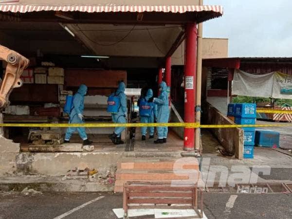 Anggota bomba melakukan sanitasi di Pasar Awam Bahau.
