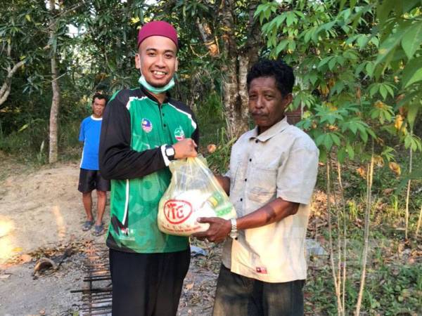 Muhammad Syazwan menghulurkan bantuan kepada seorang penduduk.