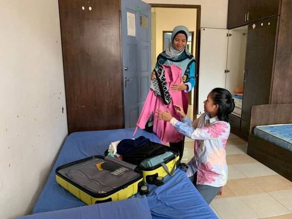 Pelajar UniSZA sedang mengemas pakaian untuk dibawa pulang Rabu ini. - Foto UniSZA