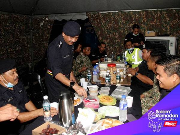 Ketua Polis Perak Datuk Razarudin Husain (dua, kiri) berbuka puasa bersama anggota polis dan tentera yang bertugas di sekatan jalan raya Susur Tambun (Arah Selatan), Ipoh hari ini.