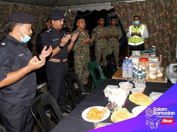 Ketua Polis Perak Datuk Razarudin Husain (dua, kiri) membaca doa berbuka puasa bersama anggota polis dan tentera yang bertugas di sekatan jalan raya Susur Tambun (Arah Selatan), Ipoh hari ini.