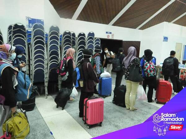 Penuntut UKM Bangi beratur dalam jarak yang ditetapkan untuk menjalani pemeriksaan kesihatan sebelum dibenarkan menaiki bas. - FOTO ROSLI TALIB