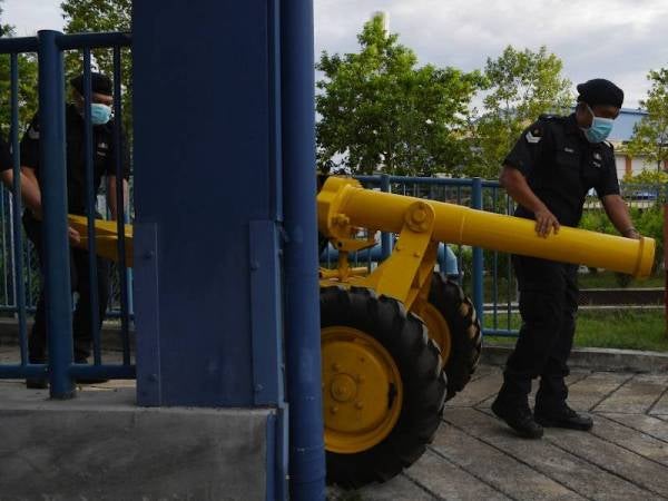 Anggota polis Sarjan Mohd Radzi Zaini (kiri) bersama Koperal Mohd Zahri Ab Rahman mengeluarkan meriam ketika membuat persediaan untuk melepaskan satu das bedilan meriam menandakan sudah masuk waktu Maghrib dan berbuka puasa di Ibu Pejabat Polis Daerah Pekan kelmarin. - Foto Bernama