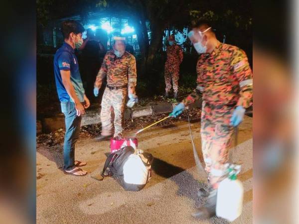 Anggota bomba melakukan proses nyahkuman/sanitasi terhadap beg pakaian pelajar di IPD Kulim. - Foto JBPM Kedah