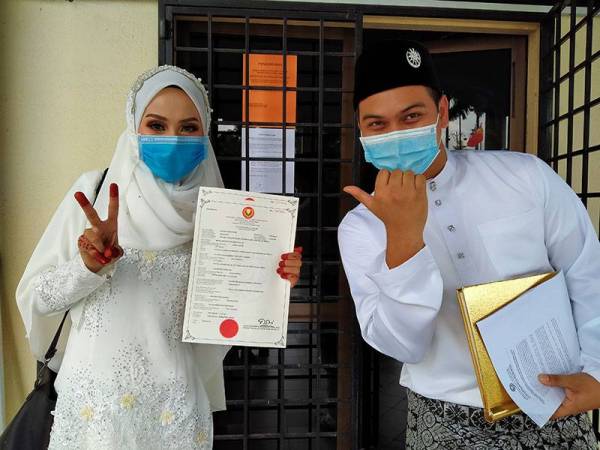 Mohd Aiman dan pasangan, Puteri Nur Shazatul Izma setelah selesai akad nikah hari ini.