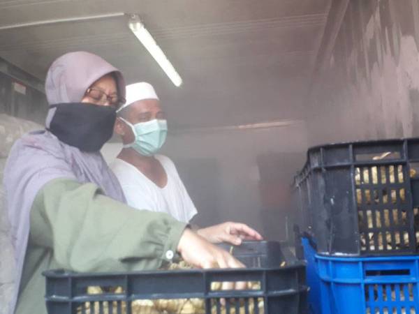 Che Non bersama suaminya, Tarmizi Yaacob melihat ketupat palas sejuk beku yang diletakkan di dalam kontena di Kampung Belukar, Hutan Kampung, Alor Setar.