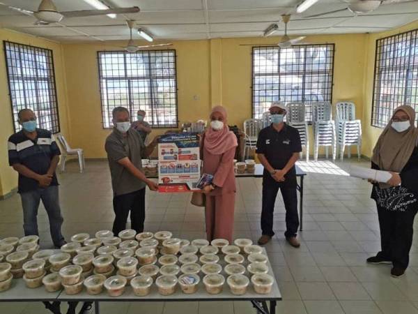 Andansura (dua dari kiri) menerima serahan bubur lambuk dari Jabatan Penerangan Malaysia Daerah Kuantan bagi penduduk DUN Beserah.
