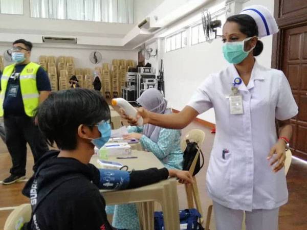 Pelajar perlu menjalani saringan sebelum dibenarkan menaiki bas.