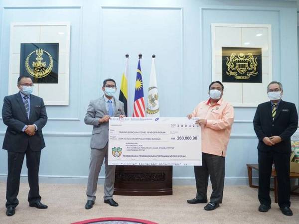 Ahmad Faizal (kiri) menerima replika cek daripada Ketua Pegawai Eksekutif PPPNP, Yahanis Yahya pada majlis penyerahan sumbangan di Pejabat Menteri Besar Perak, di sini hari ini.