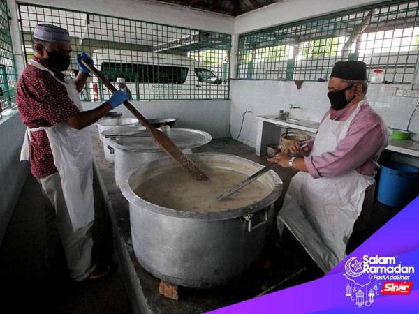 Pengerusi Masjid India Muslim Ipoh, Shaik Mujibur Rahman Mohd Yusoff (kanan) bersama setiausaha masjid Hamid Khan Salleh memasak bubur lambuk untuk diagihkan kepada petugas barisan hadapan COVID-19 sekitar bandar raya Ipoh hari ini.