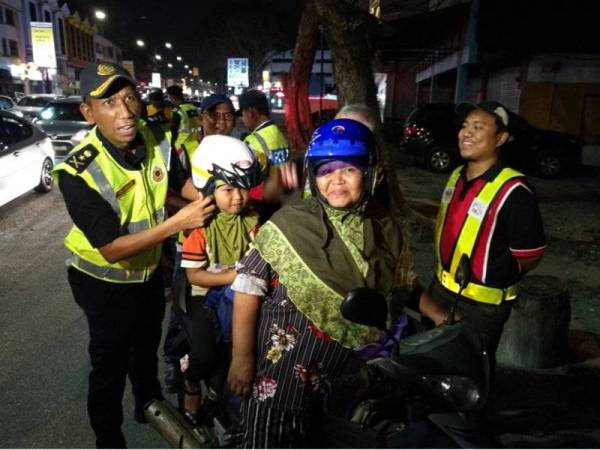 Kelihatan pegawai JPJ dan JKJR melaksanakan kempen advokasi kepada seorang pembonceng kanak-kanak pada Ops Khas Motosikal Bersepadu.