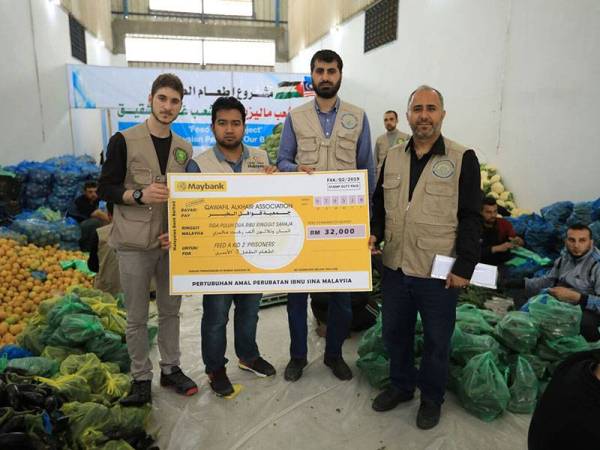 Nadir (dua dari kiri) bersama sukarelawan melakukan persediaan untuk mengagihkan pek barang dapur pra-Ramadan 2020.