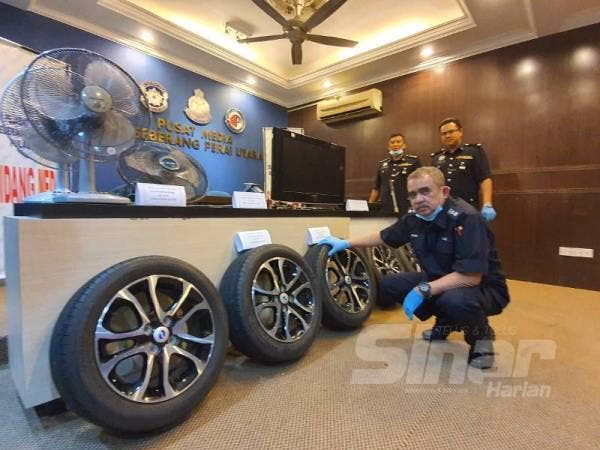 Noorzainy menunjukkan tayar sport rim yang dirampas daripada suspek.
