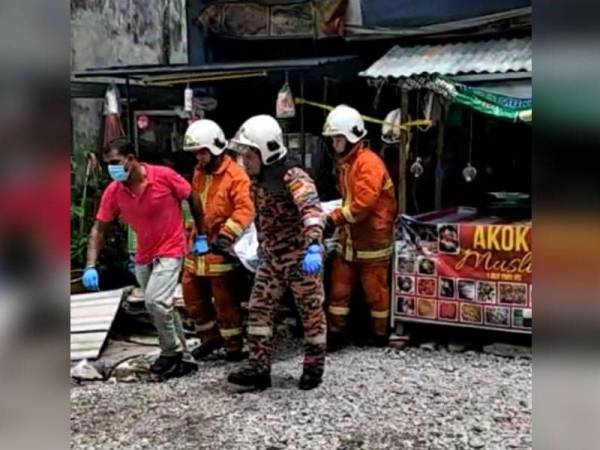 Anggota bomba membawa keluar mayat mangsa yang ditemui di tingkat atas kedai.