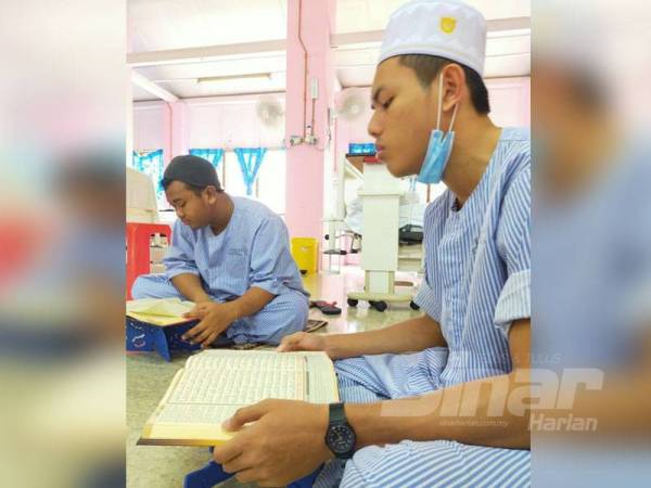 Anas (kiri) mengisi masa terluang dengan membaca al-Quran.