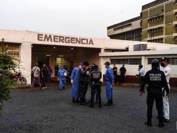Anggota perubatan dan polis menunggu ketibaan tahanan di luar hospital setelah rusuhan meletus di dalam penjara di Guanare, Venezuela. - Foto Reuters / Manuel Alvarado