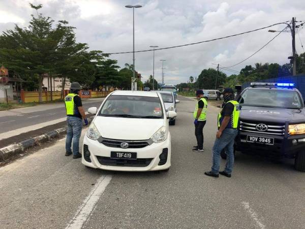 Anggota bertugas sedang melakukan pemeriksaan ke atas kenderaan dalam operasi sekatan jalan raya sepanjang PKP di sekitar daerah Kemaman. Foto ihsan FB IPD Kemaman