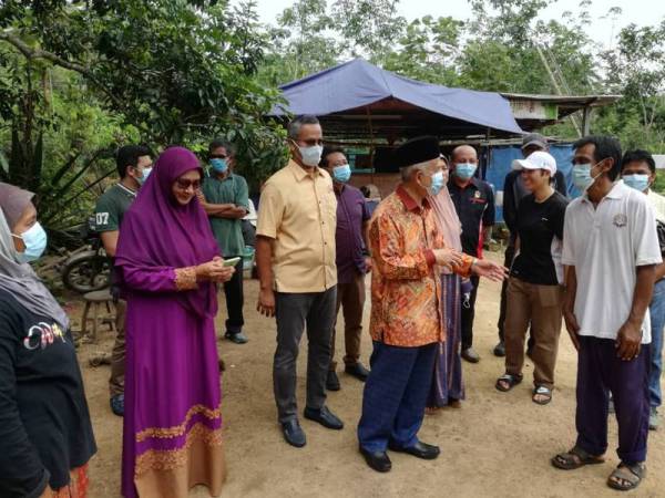 Mohammed (berbaju batik) ketika bertemu keluarga Radzuran (kanan).