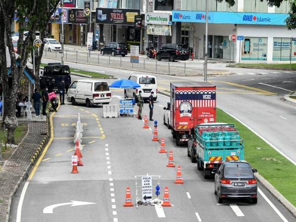 Anggota polis dan tentera memeriksa kenderaan yang melalui sekatan jalan raya sewaktu Perintah Kawalan Pergerakan (PKP) di sekitar ibu kota hari ini. -Foto Bernama
