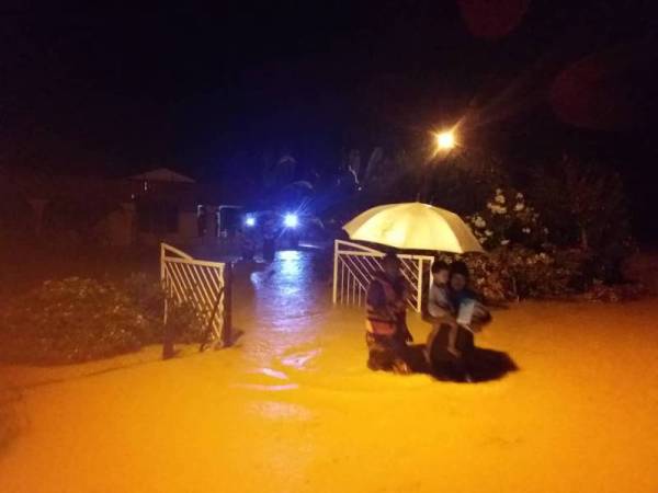 Anggota bomba membantu memindahkan mangsa banjir di Kampung Dato Johan, Jempol semalam.