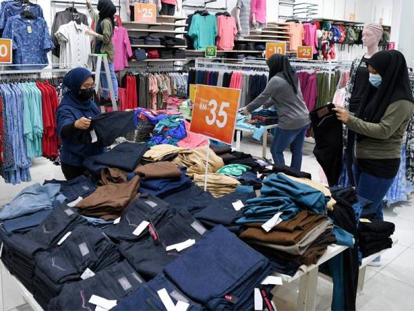 Pekerja sebuah butik pakaian, Siti Hajar Razali (kiri) bersama rakan sekerja melakukan persiapan untuk memulakan operasi pada esok ketika tinjauan di KTCC Mall, Terengganu.