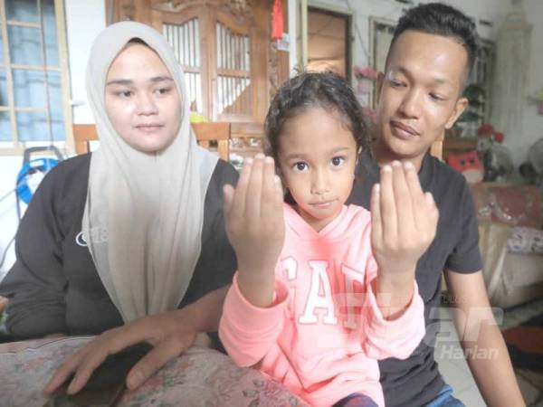 Che Tam (tengah) bersyukur kerana ayah, Azman (kanan) dan ibunya, Nurul Nadia (kiri) membuat keputusan mengantikan Atan yang hilang di rumahnya di Felda Lepar Hilir Dua.