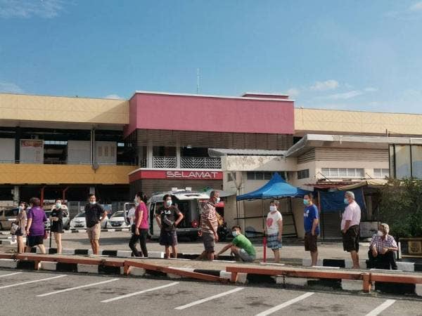 Peniaga beratur untuk membuat saringan di Pasar Besar Seremban.