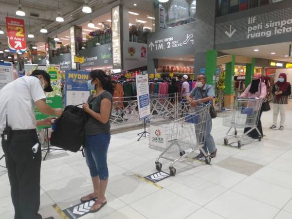 Pengunjung perlu menjalani pemeriksaan sebelum memasuki premis Mydin.