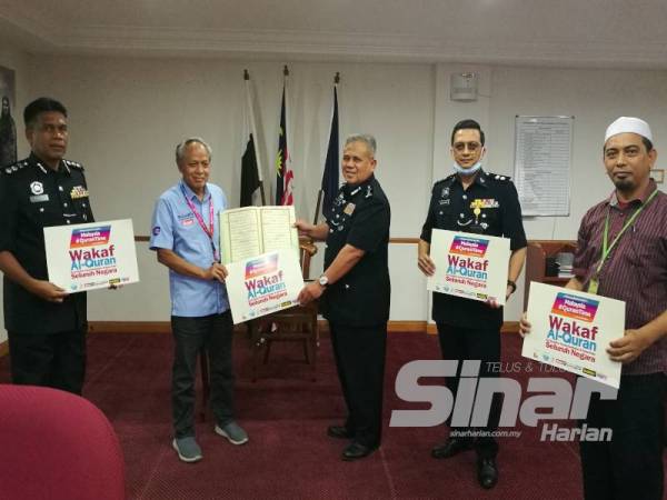 Muhammad Nasir menyerahkan naskah al-Quran yang diwakafkan kepada Abd Jalil disaksikan Wan Mohd Zahari (kiri), Md Abdu (kanan) dan Sulaiman pada majlis ringkas di IPK Pahang di sini petang semalam.