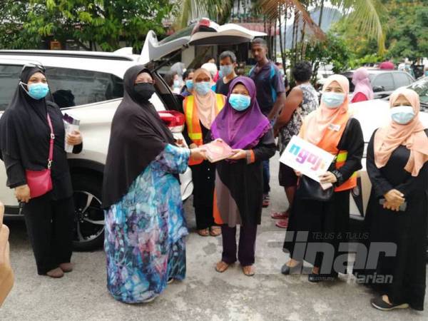 Wakil Rumah Ngaji Perak, Latipah Mohammad mengagihkan naskhah al-Quran yang diinfakkan penyumbang kepada penerima memerlukan di sini.