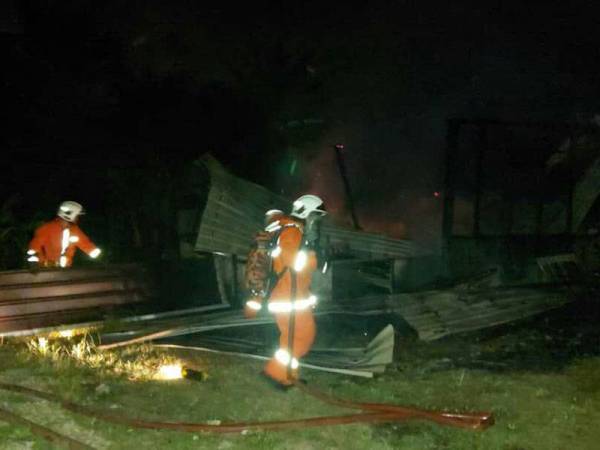Anggota bomba memadamkan kebakaran di sebuah rumah jenis separuh kekal milik pasangan warga emas di Kampung Baru, Senggarang, Batu Pahat, Johor awal pagi ini.