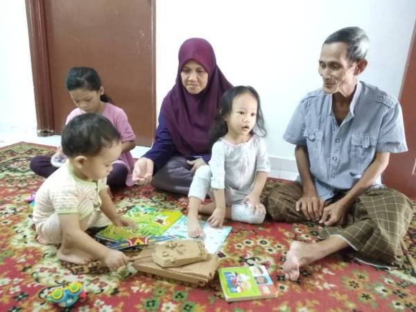 Sapiyah bersama suami, Ahmad Bintang, 67, yang terperangkap di rumah anak mereka di Klang, Selangor sedang melayani kerenah cucu ketika tempoh PKP di sana.