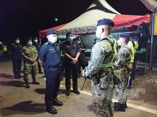 Abdul Rahim (kiri) memberikan kata-kata motivasi kepada anggota yang bertugas di sekatan jalan raya Paya Rumput, awal pagi tadi. 