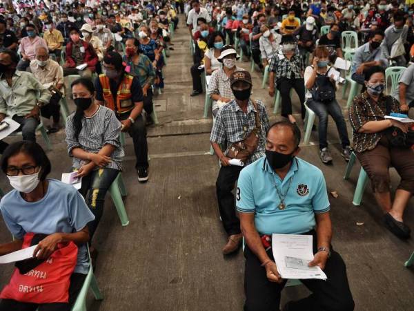 Orang ramai berhimpun di Jabatan Perhubungan Awam di Bangkok bagi menuntut bantuan Covid-19 kerajaan berjumlah 5,000 baht (RM666). - AFP