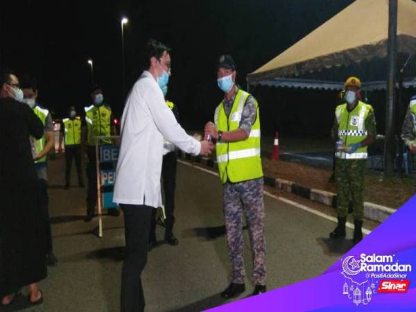 Shahril Shamsir (tengah) menyerahkan makanan sahur kepada anggita Rela yang bertugas di Indera Mahkota. 