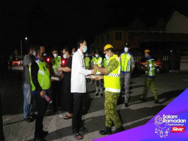 Shahril Shamsir (tengah) menyerahkan makanan sahur kepada anggita Rela yang bertugas di Indera Mahkota.
