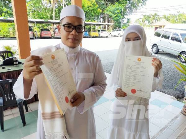 Zaliqha dan Mohd 'Athaillah menunjukkan sijil nikah yang diterima mereka setelah selesai majlis pernikahan di Pejabat Agama Kubang Pasu hari ini.