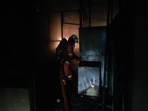 Anggota bomba menjalankan operasi pemadaman kebakaran melibatkan dua rumah di Kuala Kangsar hari ini. Foto: JBPM